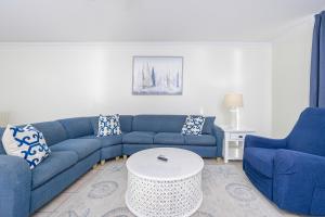 a living room with a blue couch and two chairs at Phoenix X 504 in Orange Beach