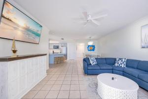 a living room with a blue couch and a kitchen at Phoenix X 504 in Orange Beach
