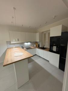 a large white kitchen with a wooden counter top at Borówkowy domek in Janik