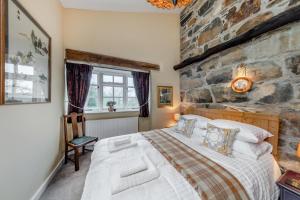 a bedroom with a large bed and a stone wall at 4 Bed in Arthog oc-b31966 in Arthog