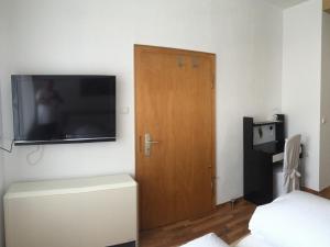 Zimmer mit einer Tür und einem TV an der Wand in der Unterkunft Gästehaus Alfons und Marianne Eifel in Trittenheim