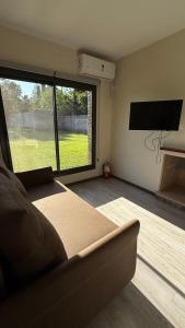 a living room with a couch and a large window at Terroir Village - Complejo en Mendoza in Guaymallen