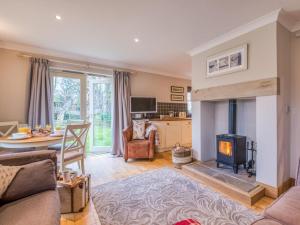 a living room with a fireplace and a table at 2 Bed in Chathill oc-77990 in Ellingham