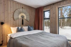 a bedroom with a bed with a fan on the wall at TH2124- Spacious ski-in out cabin in Trysilfjell with 5 bedrooms in Hovi +33 photos