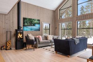 a living room with a couch and a fireplace at TH2124- Spacious ski-in out cabin in Trysilfjell with 5 bedrooms in Hovi