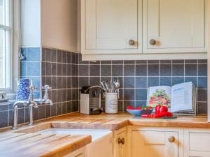 a kitchen with white cabinets and a counter top at 2 Bed in Chathill oc-77990 in Ellingham +14 photos