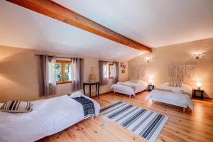 two beds in a room with wooden floors at Gîte le Moulin Samsara in Homps +58 photos