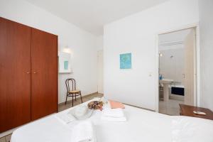 a bedroom with a bed and a chair and a mirror at Villa Calliope Kalamaki in Kalamaki +15 photos