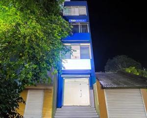 a blue and white building with a garage at Hotel Nidhivan Palace in Surat