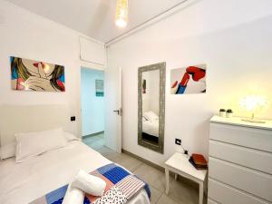 a white bedroom with a bed and a mirror at Apartment Sagrera in Barcelona