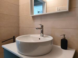a bathroom with a white sink and a mirror at in Piazza in Mezzocorona +14 photos