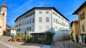 a large white building with a clock tower at in Piazza in Mezzocorona
