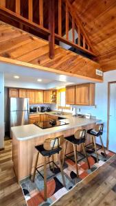 a kitchen with a large island with chairs in it at Guys Getaway Cabin in Ruidoso