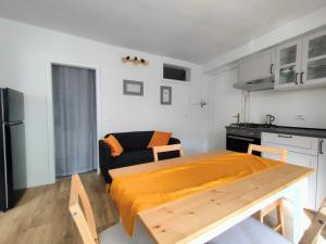 a kitchen and a living room with a table and a couch at in Piazza in Mezzocorona