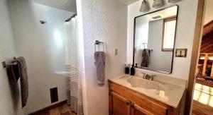 a bathroom with a sink and a mirror at Guys Getaway Cabin in Ruidoso +33 photos