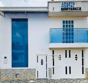 a white building with blue doors and a sign at Casa Quintanilla in Villanueva