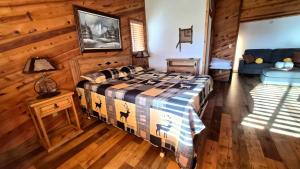 a bedroom with a bed and a couch in a room at Guys Getaway Cabin in Ruidoso
