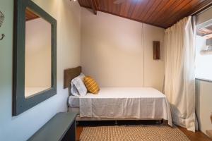 a small room with a bed and a mirror at Para Vos y Porque Si in Morro de São Paulo