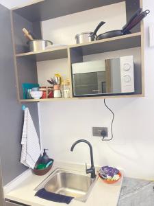 a kitchen with a sink and a microwave at Naisolas place in Marimbeti