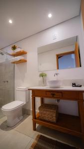 a bathroom with a sink and a toilet and a mirror at Pousada Caraíba in Rifaina +56 photos