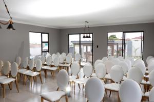 a room with white chairs and tables and windows at Siyamthanda Boutique in Louis Trichardt +103 photos