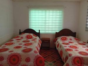 two beds sitting next to each other in a bedroom at Refugio Costero in Caldera