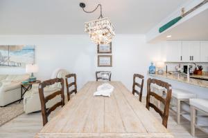 a dining room with a wooden table and chairs at Wind Drift 310S condo in Orange Beach
