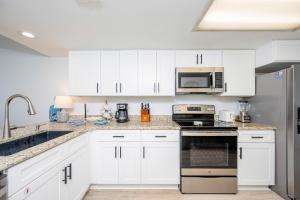 a kitchen with white cabinets and stainless steel appliances at Wind Drift 310S condo in Orange Beach