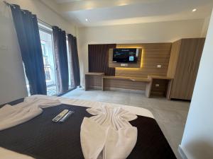 a bedroom with a bed with a tv on the wall at Baga Sea shine in Baga