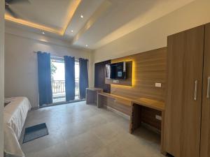 a bedroom with a bed and a tv on a wall at Baga Sea shine in Baga