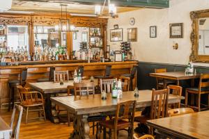 a restaurant with wooden tables and chairs and a bar at James Buchanan Hotel, Trademark Collection by Wyndham in Mercersburg