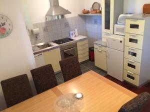 a kitchen with a wooden table and chairs in a kitchen at Apartment Nada in Ston