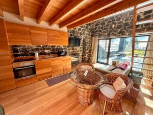 a kitchen with a table and chairs in a room at Palheiros do Serrado by Real Vision in Estreito da Calheta