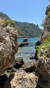 a boat is docked on a river with rocks at Papiri Beach Summerhouse in Agios Georgios