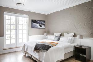 Un dormitorio con una gran cama blanca y una ventana en Hotel Ódinsvé, en Reikiavik