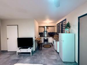 a kitchen with a white refrigerator and a table at Les Douces Nuits Saint Pierre in Saint-Pierre