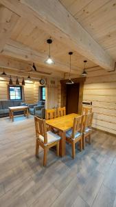 a dining room with a wooden table and chairs at Domek u Hillów in Stronie Śląskie
