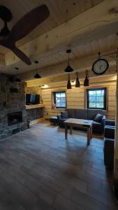 a living room with couches and a stone fireplace at Domek u Hillów in Stronie Śląskie