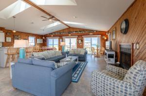 a living room with blue couches and a fireplace at Desi's Delight - S Nags Head MP 20.5, Ocean View, 30 Yards to Beach, Cargo Lift, YR Flex Stays in Nags Head
