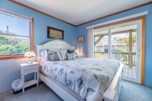 a bedroom with a white bed and a window at Desi's Delight - S Nags Head MP 20.5, Ocean View, 30 Yards to Beach, Cargo Lift, YR Flex Stays in Nags Head