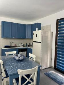 a kitchen with blue cabinets and a table and a refrigerator at Villa Ohana in Pula