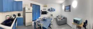 a kitchen with blue cabinets and a table and a refrigerator at Villa Ohana in Pula