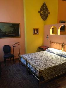 a bedroom with a bed and a chair at Casa Dondini in Bologna