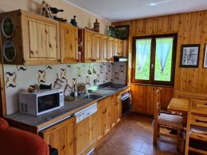 a kitchen with wooden cabinets and a microwave at Ca' Delle Nevi in SantʼAntonio