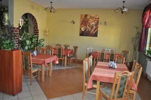 a restaurant with tables and chairs and a painting on the wall at Zajazd Magrani in Lubawka +1 photo