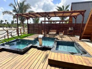 a swimming pool on a wooden deck with a pergola at LIMMAT Chalés- Presidente Juscelino, MA in Morros