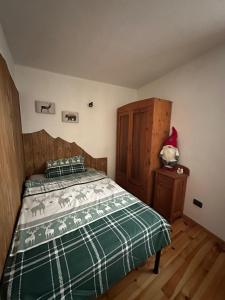 a bedroom with a bed and a wooden cabinet at Il nido delle cime in Capriana