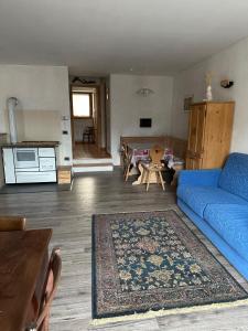 a living room with a blue couch and a table at Il nido delle cime in Capriana +3 photos