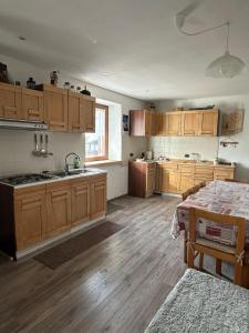 a kitchen with wooden cabinets and a sink and a table at Il nido delle cime in Capriana