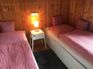 a room with two beds and a table with a lamp at Ferienhaus Bruno - Südhanglage mit 2 Schlafzimmern in Feldberg